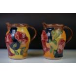 A pair of pottery jug vases of baluster form, with incised floral and foliate decoration and