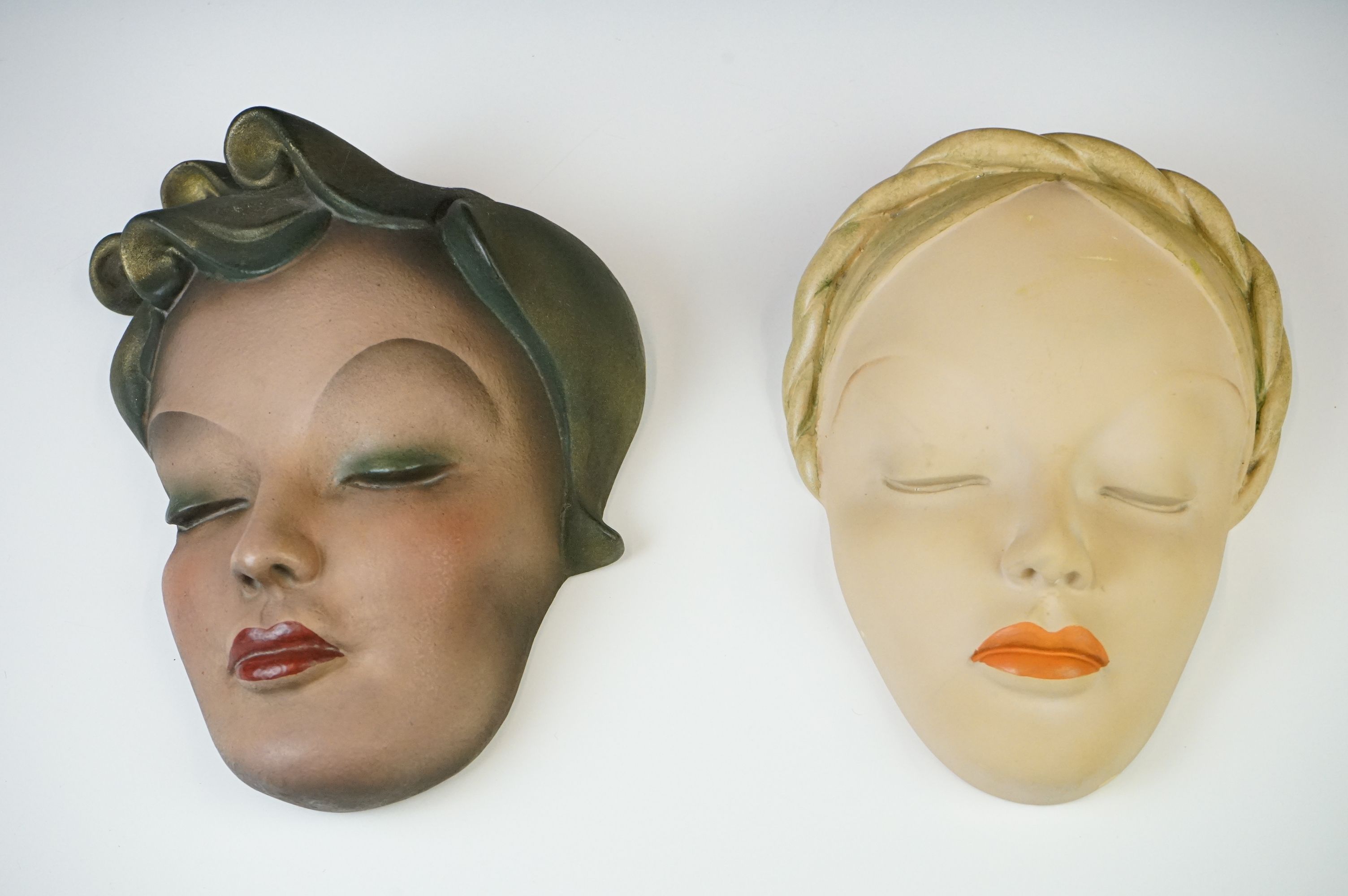 Two Leonardi Art Deco painted plaster wall masks depicting young ladies, both with impressed