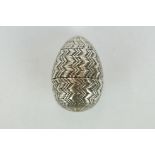 Unmarked silver pomander, modelled as an egg with punched and engraved zig zag decoration, circa