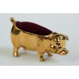 A brass cased pig pincushion