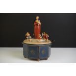 A German painted wooden musical carousel of octagonal form surmounted by Mary holding the baby