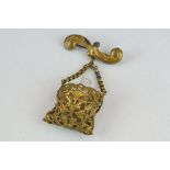 19th century miniature scent bottle contained within pierced cover suspended from a bar brooch,