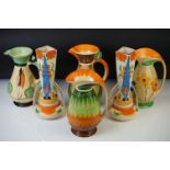 Four Myott, Son & Co hand painted Art Deco footed jugs, decorated with colourful floral, foliate and