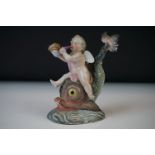 A Continental porcelain figure of a cherub on a dolphin, h: 11.5cm