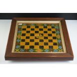 A 19th century Folk Art painted glass chess board/draughts board, with naively decorated borders, in