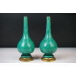 Pair of Chinese green glazed bud vases of baluster form, decorated with faces and foliate