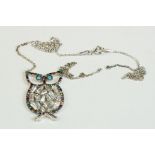 A silver owl shaped necklace set with semi-precious stones