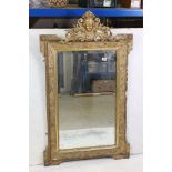 19th century Gilt Framed Mirror, the scrolling crest holding a face mask and with moulded floral