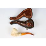 Two meerschaum pipes, one cased with ornate silver decoration, lion's head front in lined case,