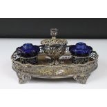 A silver plated pierced decorated standish double ink will with blue glass wells.