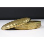 An antique 18th century oval brass snuff box with ornate chased decoration.