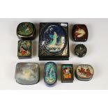 A collection of nine Russian lacquerware trinket boxes with traditional decorative scenes.