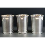 Set of three 20th century sterling silver beakers of plain polished tapering form, ribbed rims, gilt