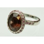 Garnet and pink sapphire 18ct white gold cluster ring, the oval mixed cut brownish-orange garnet