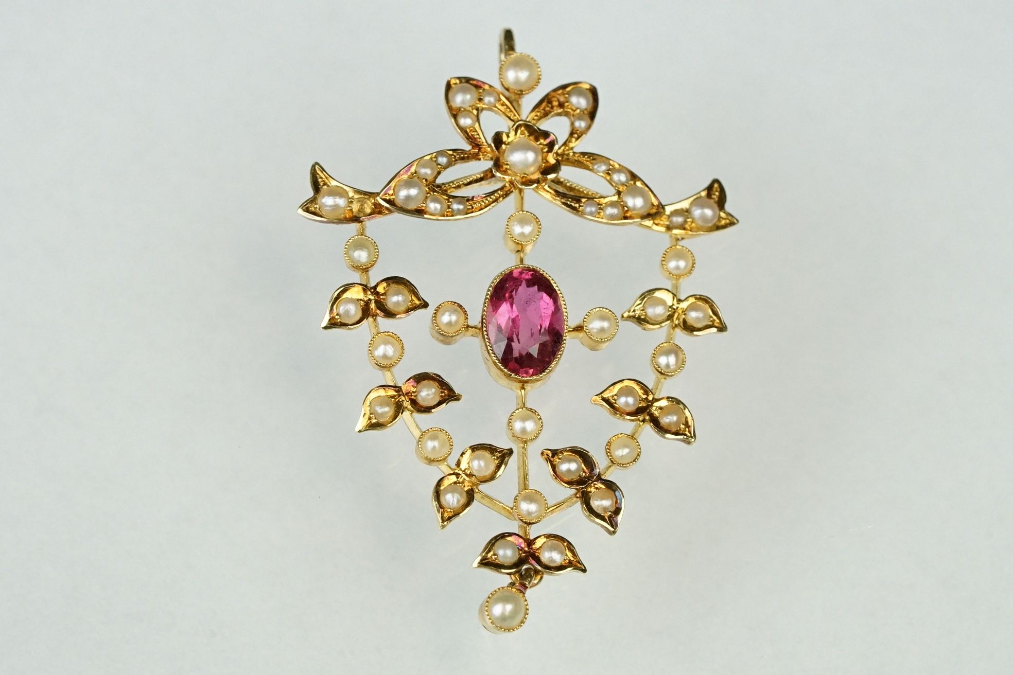 Edwardian tourmaline and seed pearl unmarked yellow gold pendant, the oval mixed cut pink tourmaline