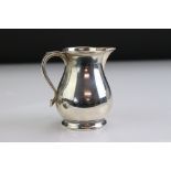 Mid 20th Century silver cream jug of plain polished baluster form, with a sparrow beak spout, ribbed