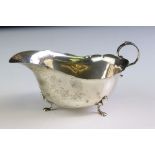 Silver sauce boat raised on three feet, scroll handle, pie crust border, makers William Suckling