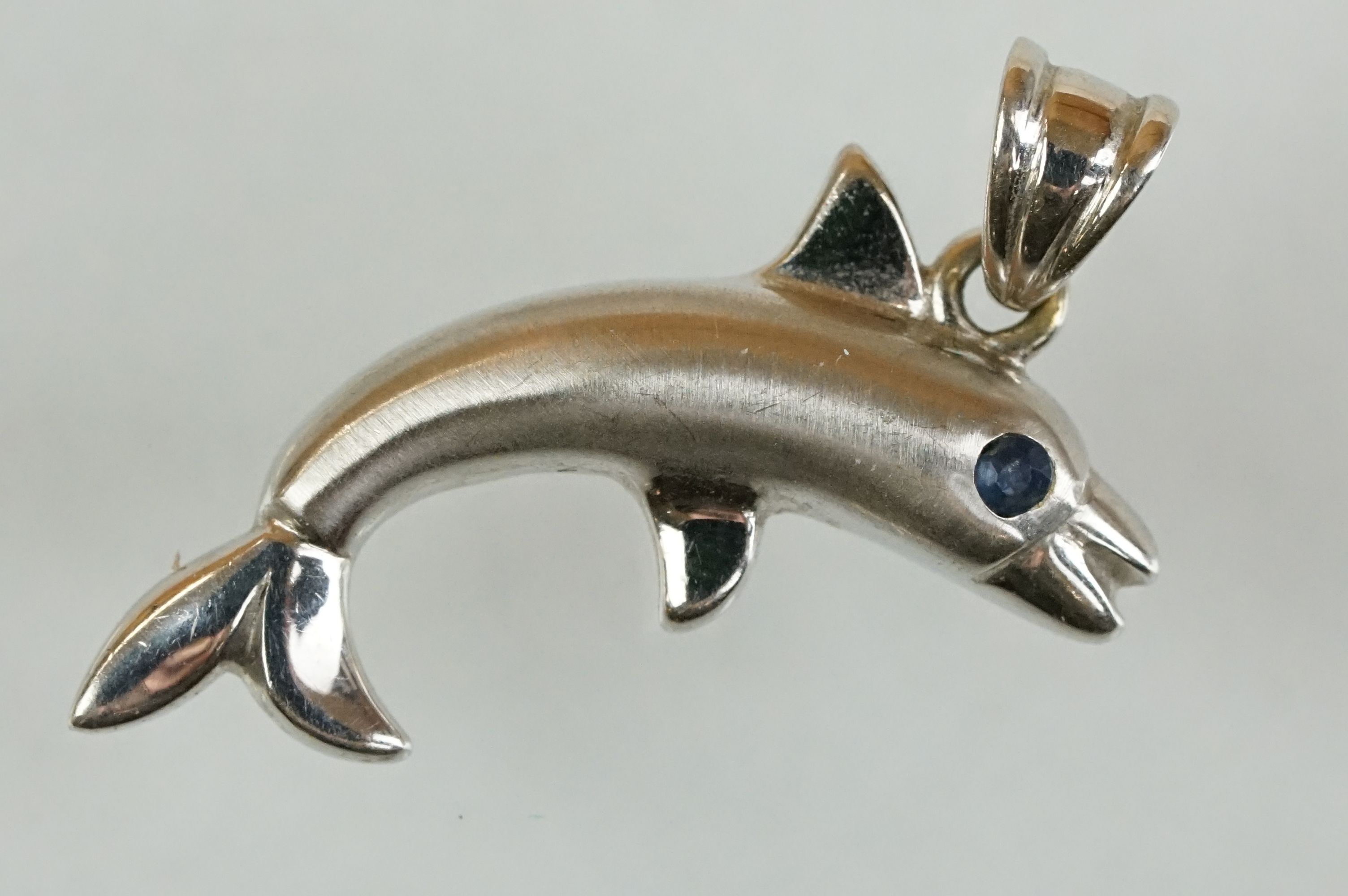 14ct white gold pendant modelled as a dolphin with sapphire eye, length approx 2.5cm