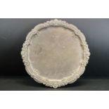 Edwardian silver salver raised on four claw feet, cast foliate and stylised shell decoration to