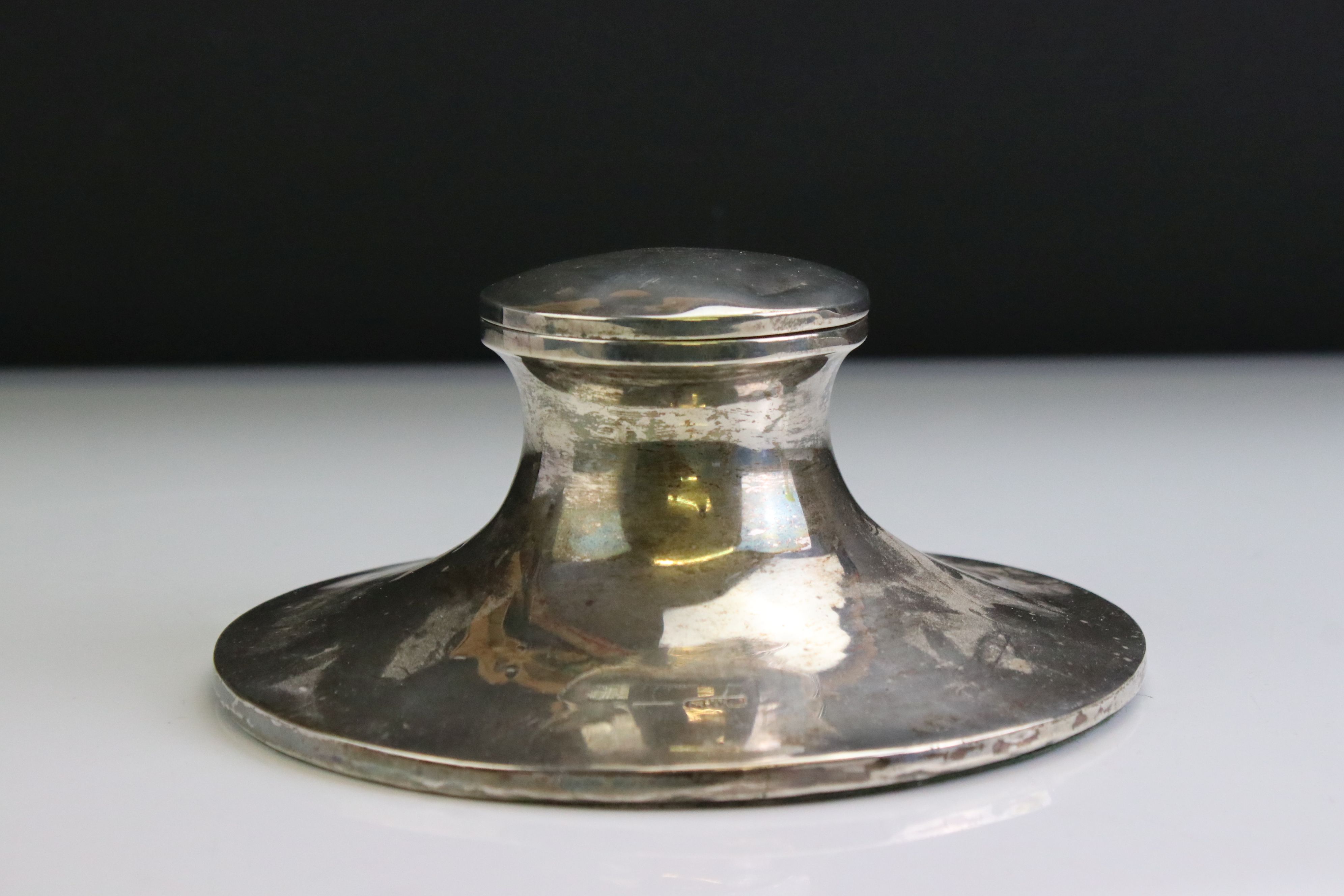 George V silver capstan desk inkwell of plain polished form, with hinged lid and clear glass