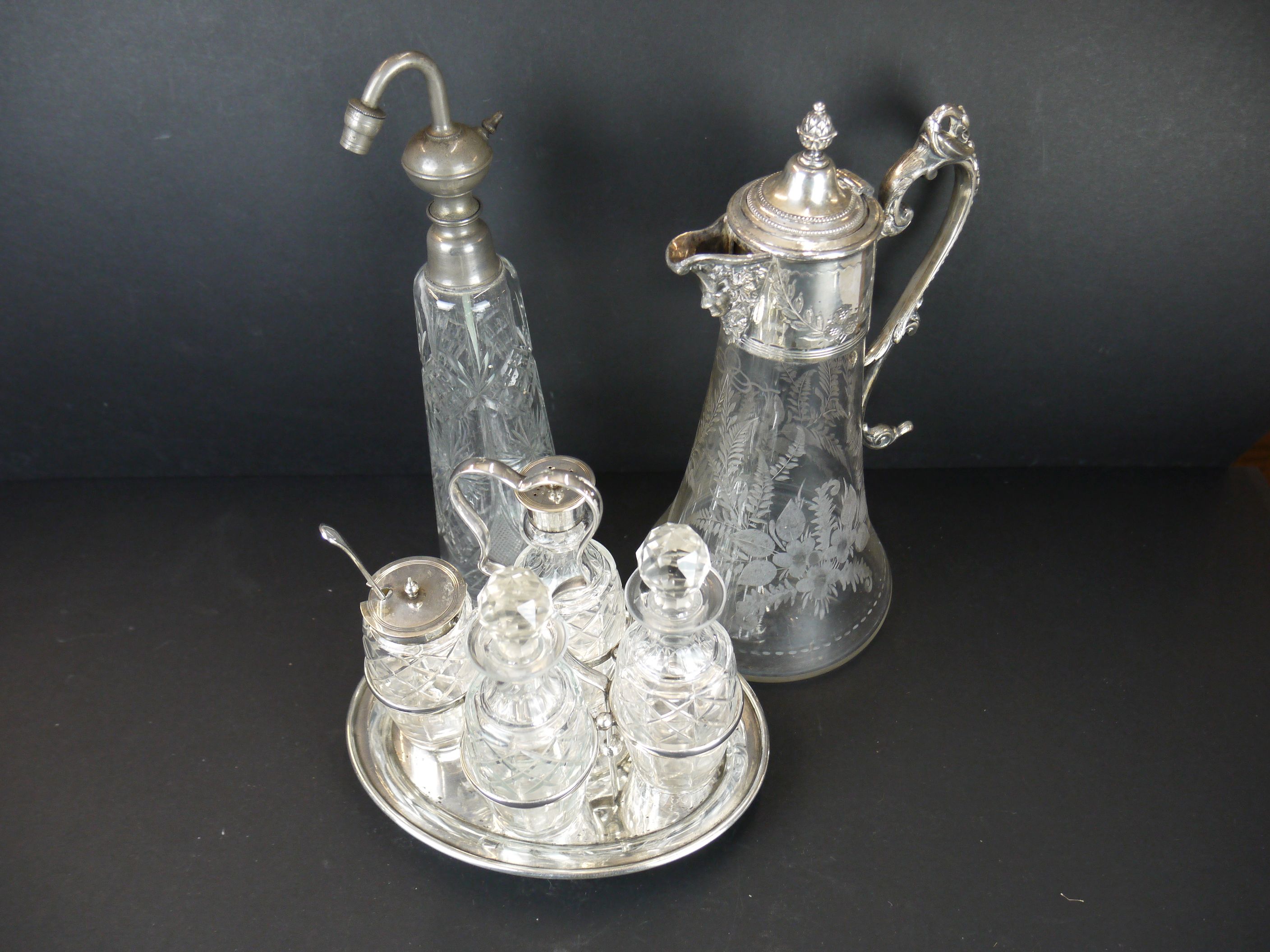 A silver plate and cut glass condiment set together with a silver plate and cut glass claret jug.