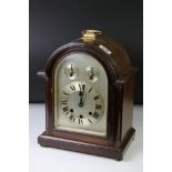 Edwardian mahogany chiming mantle clock with arched silvered dial, poker-style hands, slow/fast