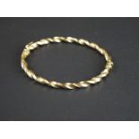 A fully hallmarked 9ct gold ladies twist bangle with safety clasp.