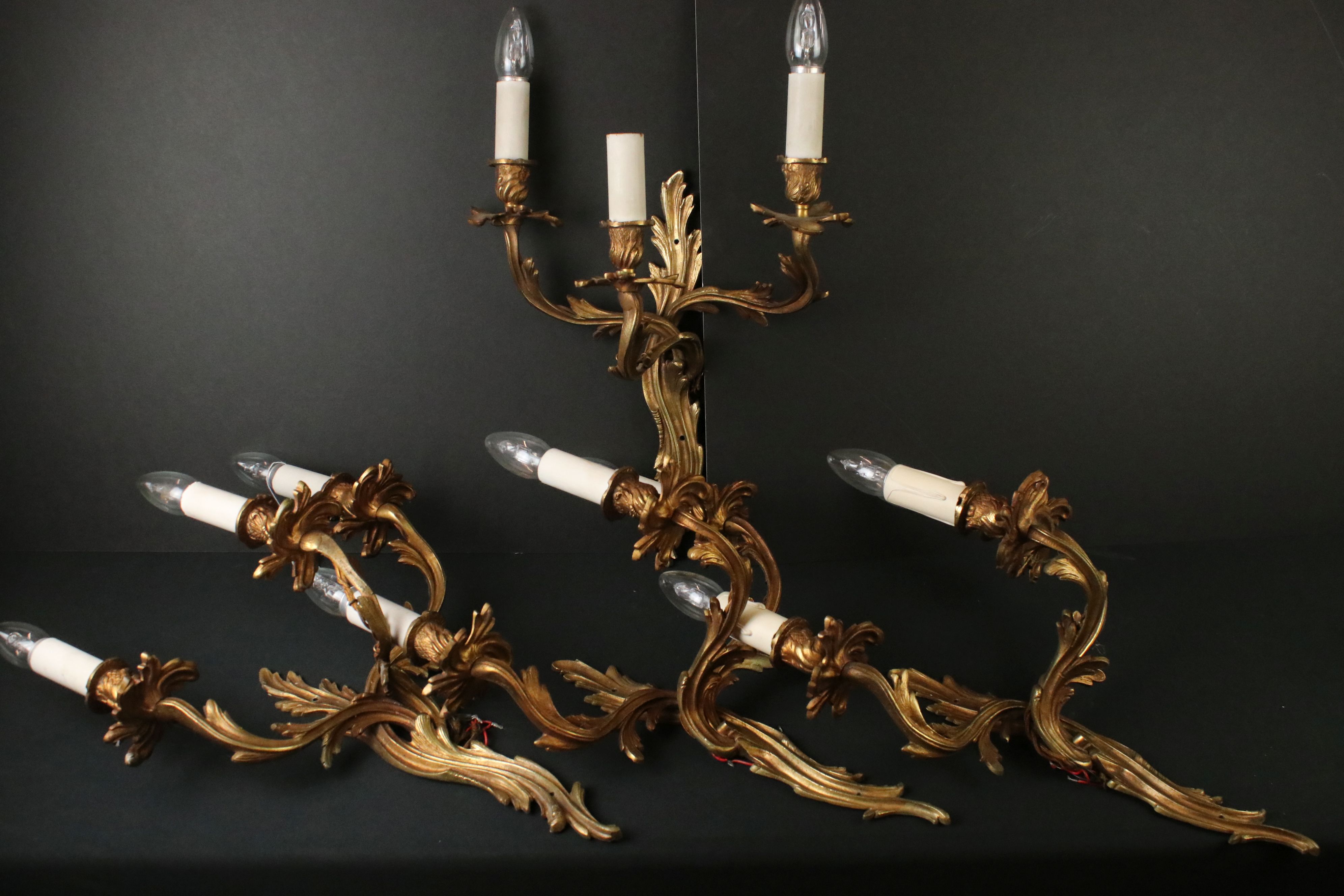 Set of Four Gilt Metal Foliate Scrolling Three Branch Wall Electric Lights in the rococo manner,