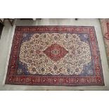 Sarouk Carpet, the central cream ground with stylised floral decoration surrounded by a red and blue