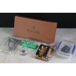 A collection of watch related items to include Rolex watch parts box, clamp, Gowlands eyepiece,