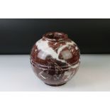 Polished marble vase of spherical footed form, with tones of red and off-white, moulded rim and