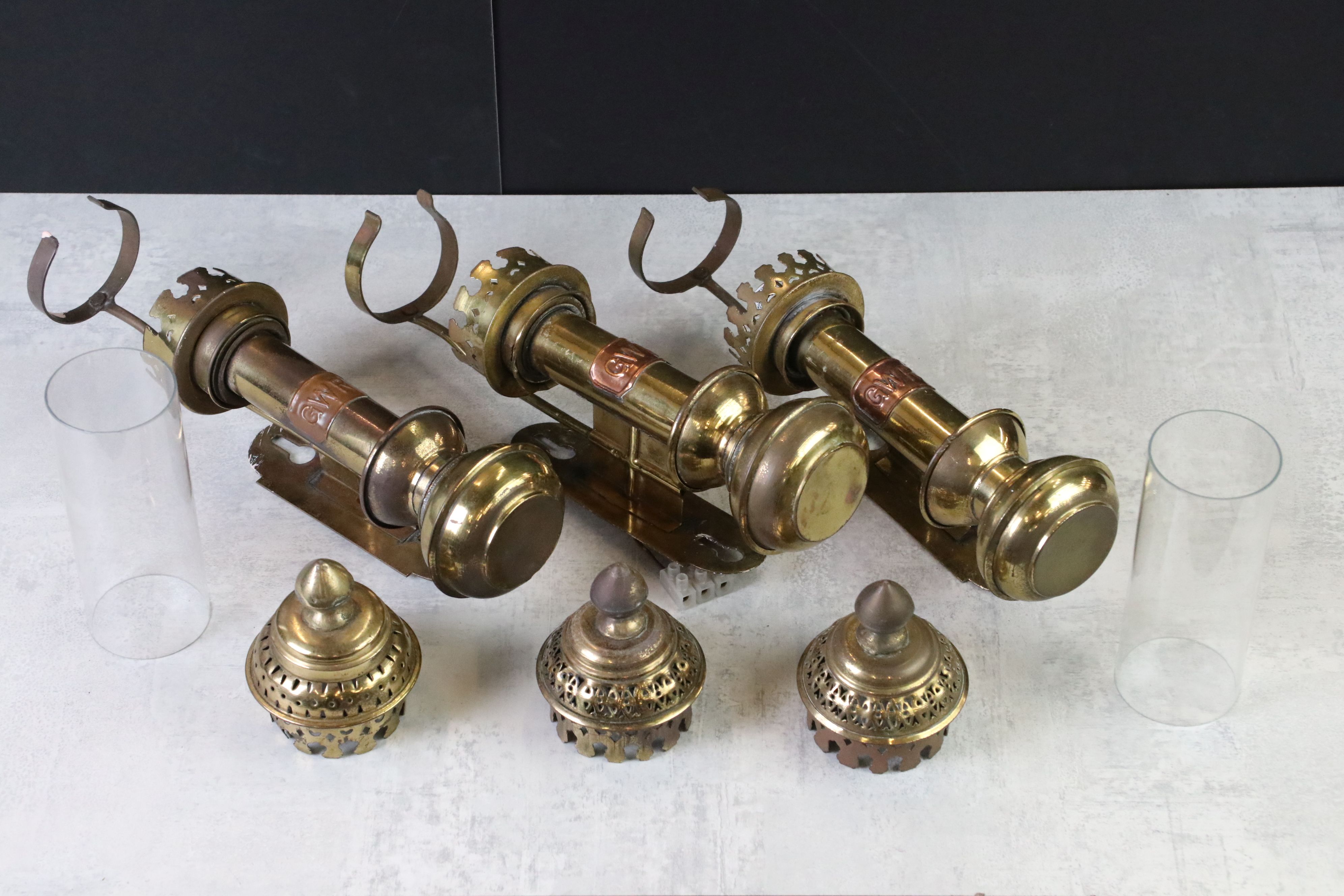 Three Brass ' GWR ' Wall Mounted Railway Carriage Oil Lamps, two with the glass chimneys, 27cm high