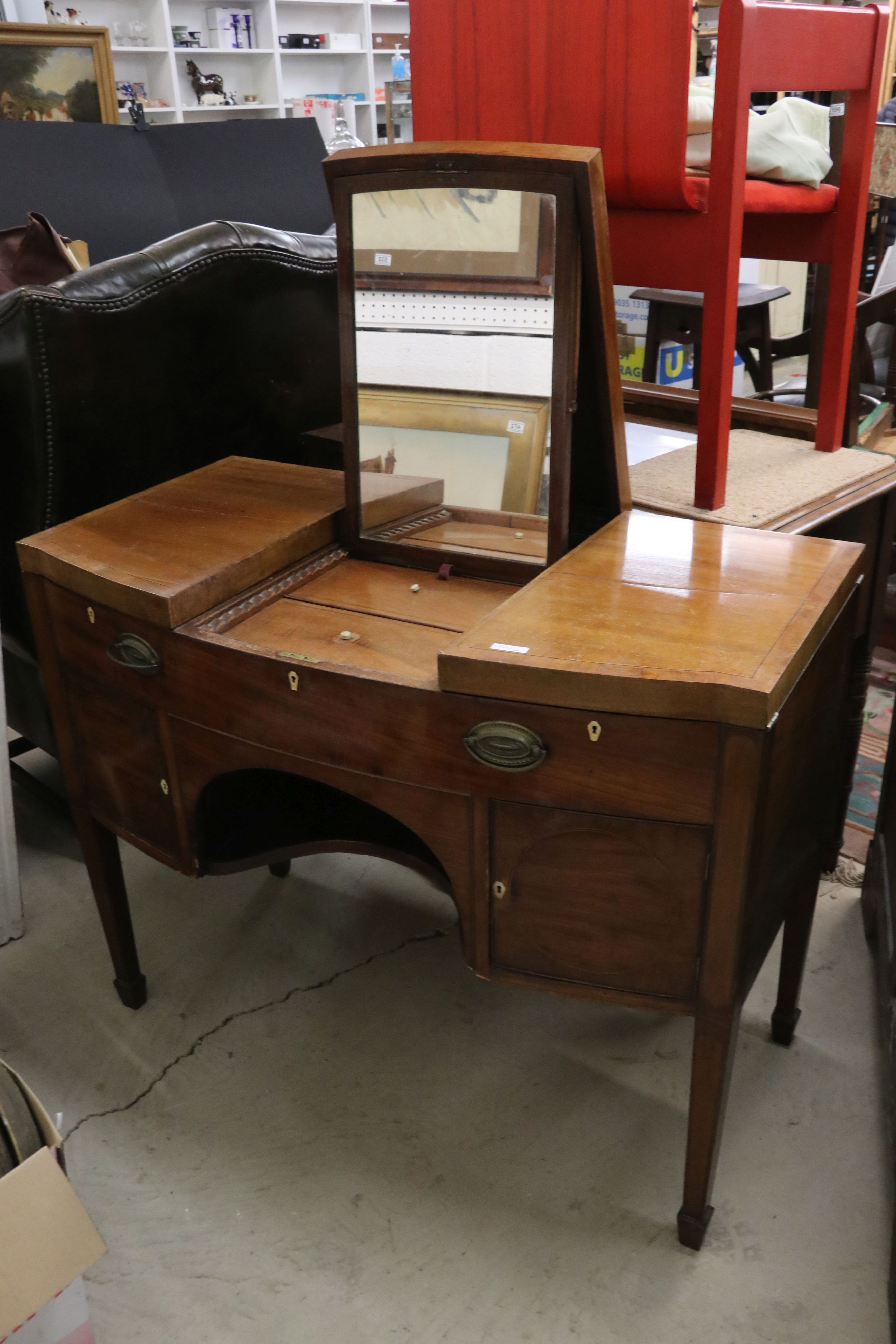 George III Mahogany bow front enclosed Dressing Table, the central hinged lid enclosing a ratchet