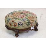 Victorian circular Footstool with wool work upholstered top and base with four carved scroll feet,