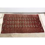 Pakistan Bokhara Rug with a pattern with three rows of twelve guls within a border, 174cm x 110cm