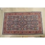 Hereke Wool Red and Blue Ground Rug with floral pattern within a border, 259cm x 152cm
