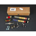 A small box of collectables to include military medal bars, cufflinks and a RAF tin clip.