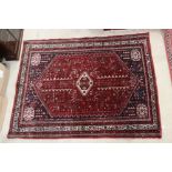 Kurdish Red Ground Wool Rug with central gul surrounded by stylised animals and flowers within a
