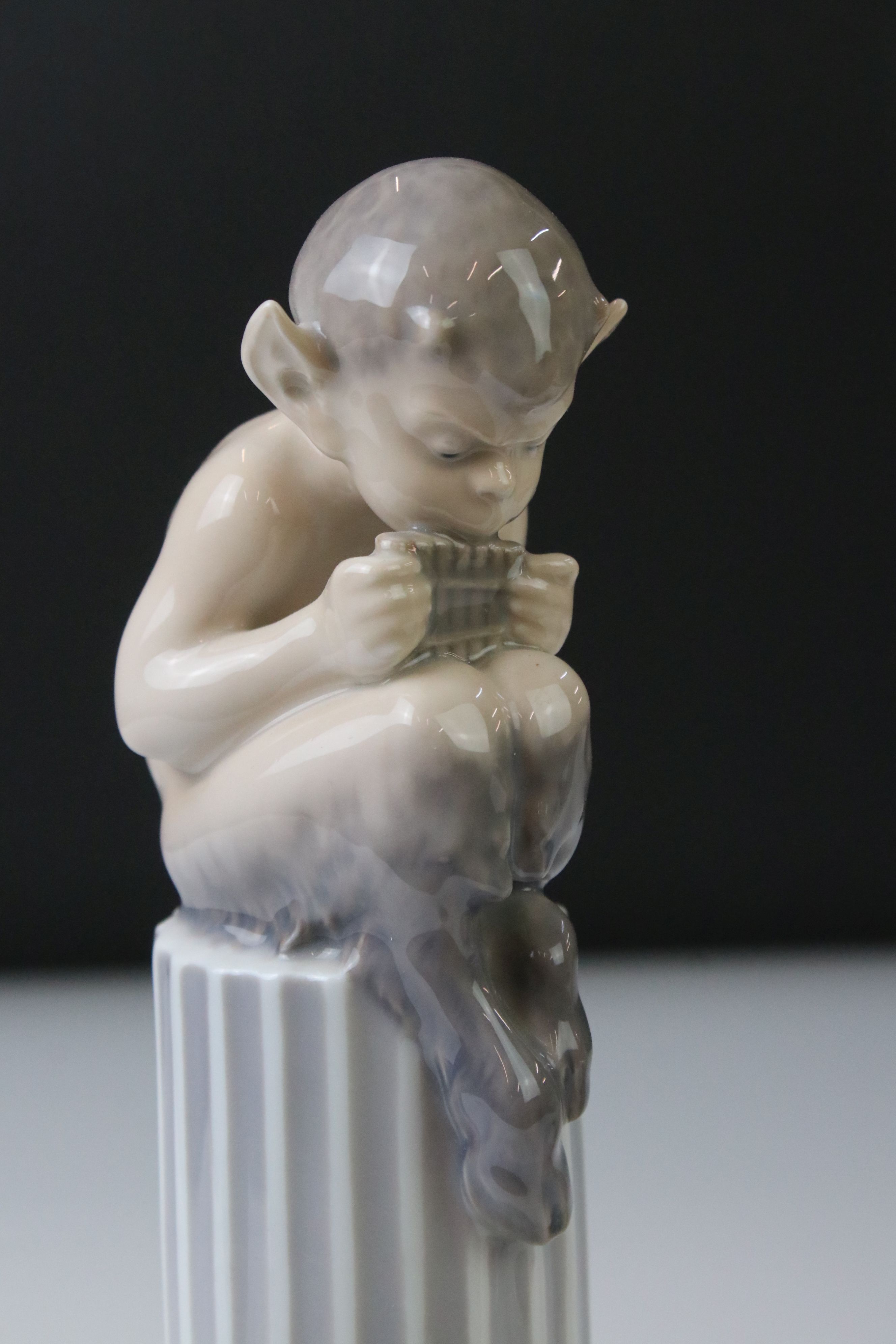 Two Royal Copenhagen porcelain figures to include a faun playing a mouth organ seated on fluted - Image 2 of 9