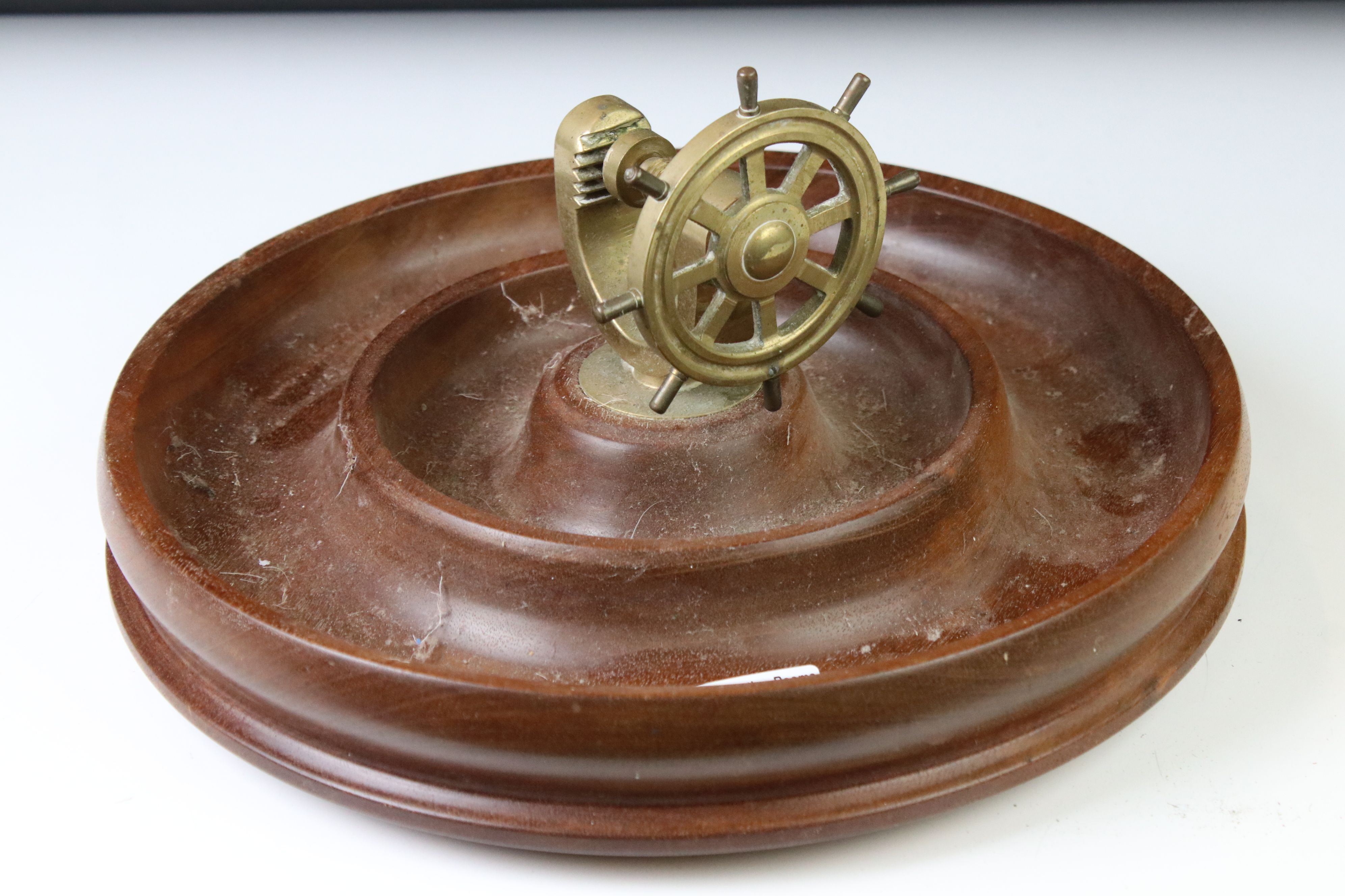 Novelty turned wooden nut dish mounted with a brass ship's wheel nutcracker, approx 29cm diameter