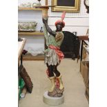 African figural painted plaster jardinière stand, in the form of a young man in native dress, on a