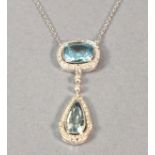 An 18ct white gold topaz and diamond pendant, comprising an emerald cut stone within a diamond