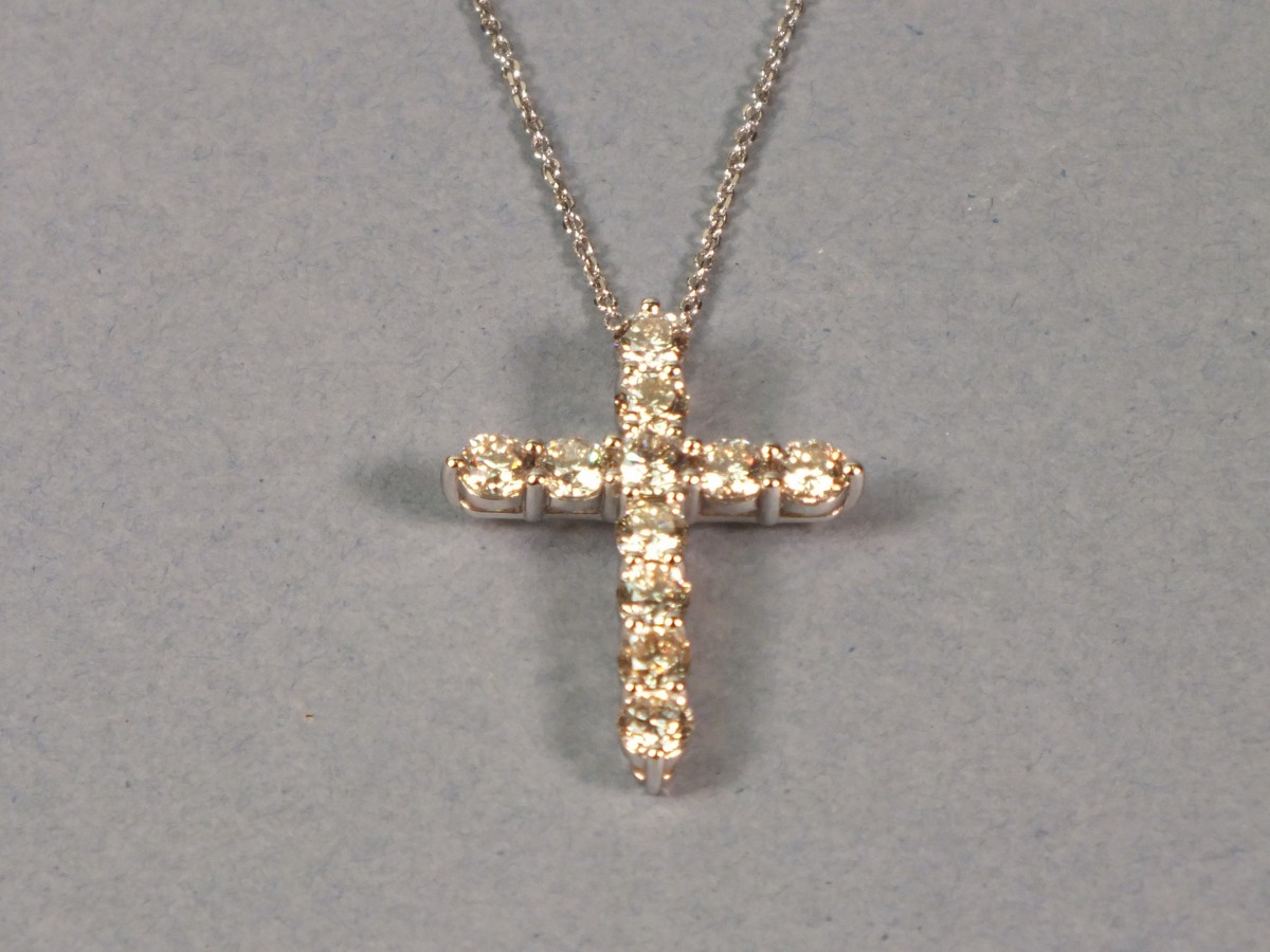 An 18ct white gold diamond set cross, with an arrangement of eleven round brilliant cut stones, on a