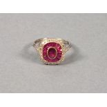 A platinum ruby and diamond dress ring, the central stone within a band of calibre cut rubies with a