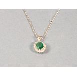 A diamond and emerald pendant, the oval cut central stone within a band of diamond, set in 18ct
