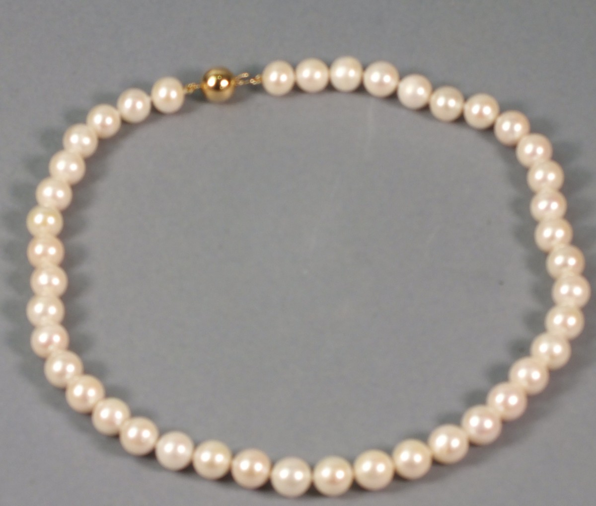 A string of freshwater pearls, of uniform dimensions with a 9ct gold clasp, 44cm long