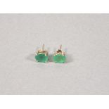 A pair of emerald ear studs, the oval cut stones claw set in silver, 1.5gms