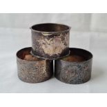A pair of foliage engraved napkin rings B'ham Sheffield 1900 by JD and another plain - 94 gms