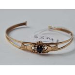 A gold bangle set with a blue sapphire 9ct - 5.1 gms