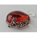 A large 5cm long amber brooch in silver mount with grape & vine leaf decoration 29g
